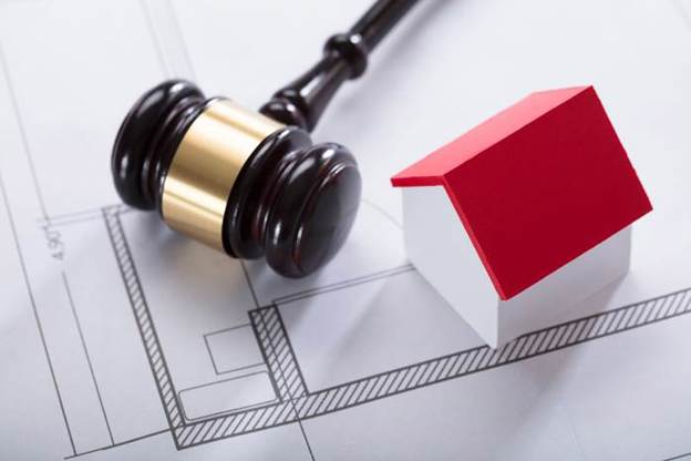 A gavel and a small house on a blueprint

AI-generated content may be incorrect.